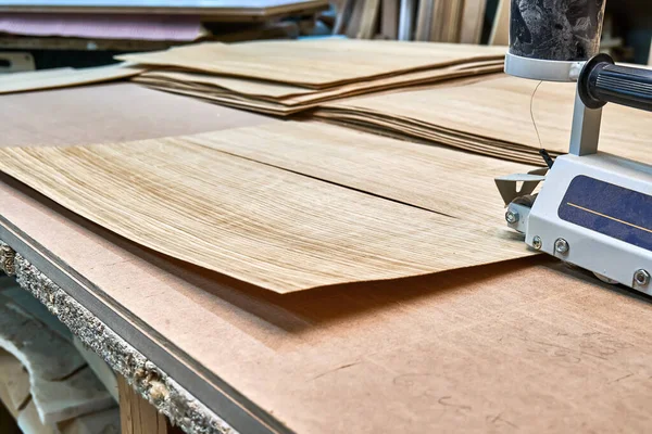 Oak veneer. Oak texture. Veneer splicing process with veneer hand splicer in woodshop. Close-up