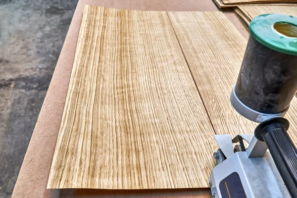 Oak veneer. Oak texture. Veneer splicing process with veneer hand splicer in woodshop. Close-up