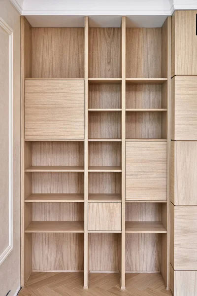 Wooden bookshelves. Wooden bookcases and wall panels made of oak veneered MDF. Close-up