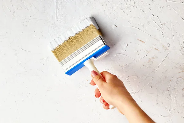 Pintura de mano femenina con superficie de pared de cepillo . —  Fotos de Stock