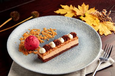 Çikolatalı bisküvi, krema ve karamelli fındıklı bir dilim pasta..