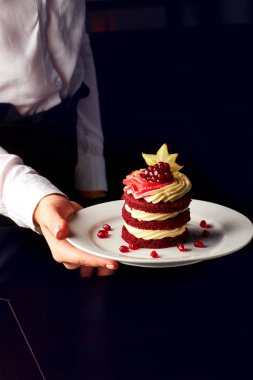 Nar ve karambola ile servis edilen kırmızı kadife kek.