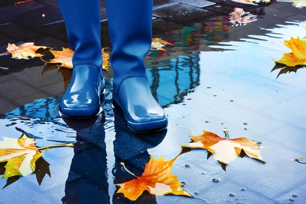 Mujer con botas de lluvia azules de pie en charco —  Fotos de Stock