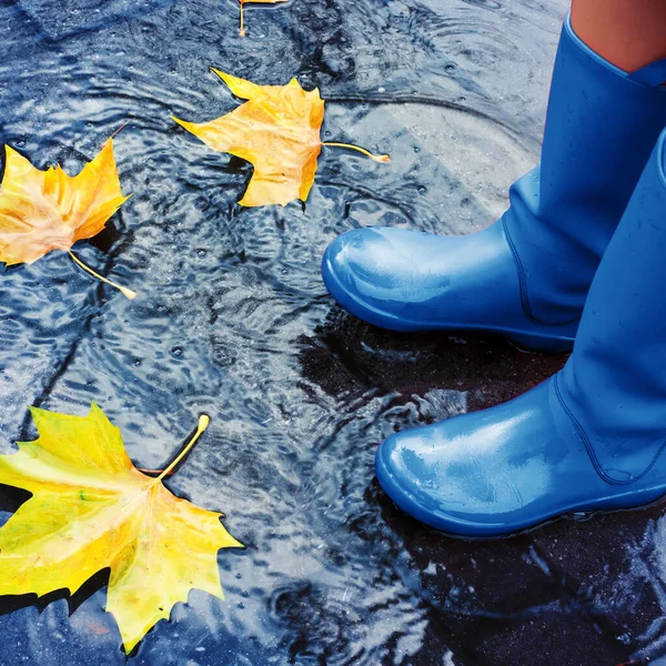 Mujer con botas de lluvia azules de pie en charco —  Fotos de Stock