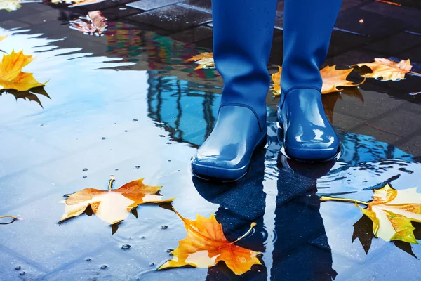 Mujer con botas de lluvia azules de pie en charco —  Fotos de Stock