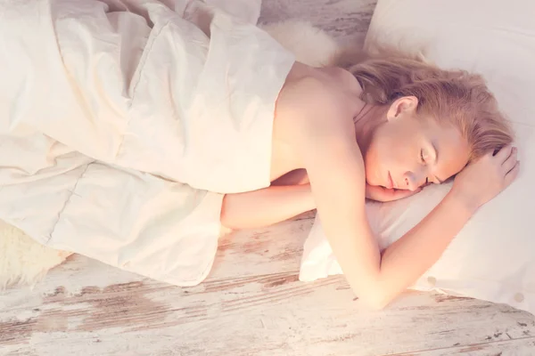 Morning light illuminates woman sleeping in bed — Stock Photo, Image