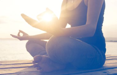 Sahilde bir yoga poz üzerinde meditasyon kadının el