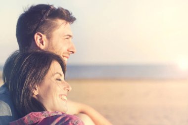 Güneşin önünde konuşurken gülümseyen Çift