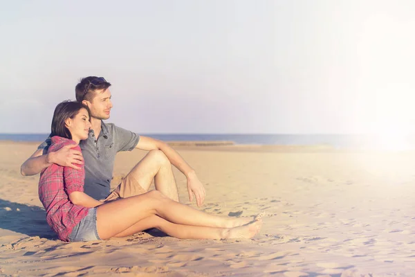 Casal abraçando admira o pôr do sol no oceano — Fotografia de Stock
