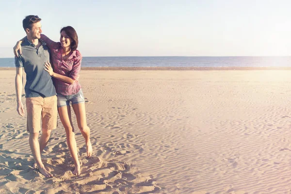 Glückliches Paar spaziert am Strand entlang — Stockfoto