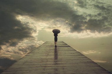 mysterious woman with umbrella crosses a bridge to the threatening sky clipart