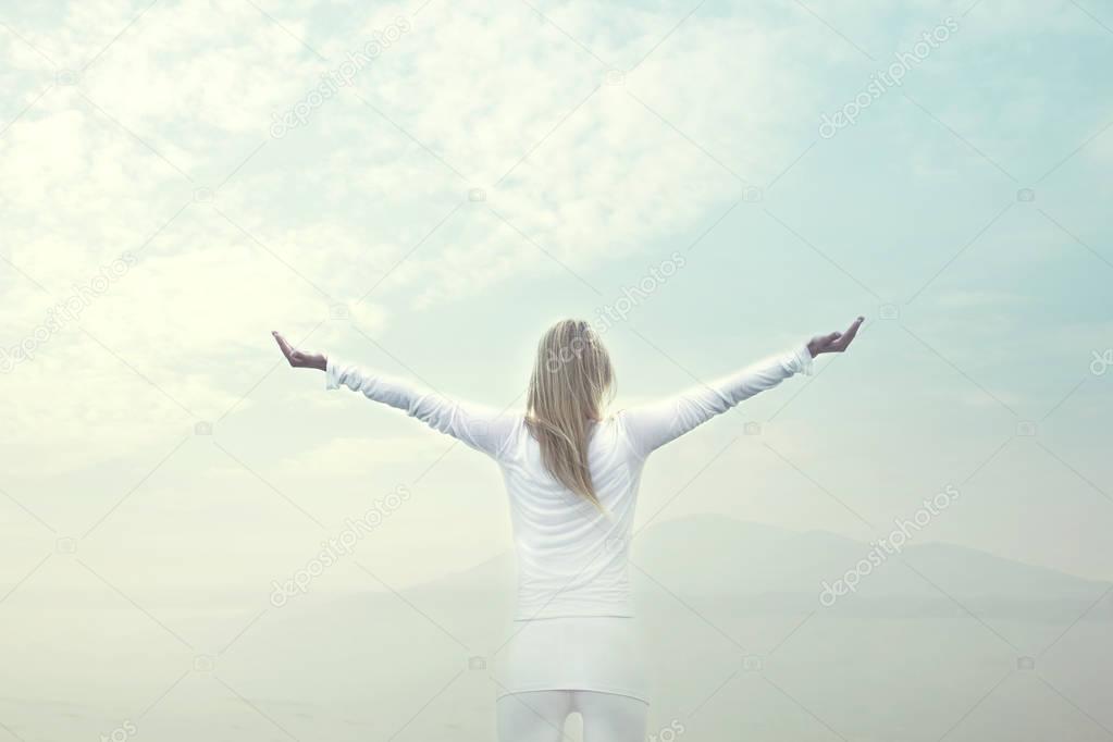 woman takes a breath in front of a blue sky