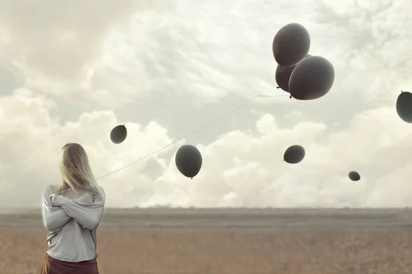 Ensam kvinna med svarta ballonger gömde ansiktet — Stockfoto