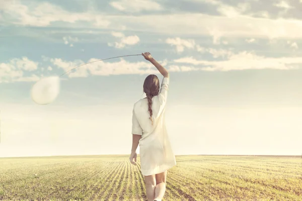 Mujer soñadora caminando hacia el infinito con su globo blanco en la naturaleza —  Fotos de Stock