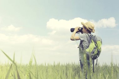 Genç çocuk explorer sonsuz O'nun dürbün ile görünüyor.