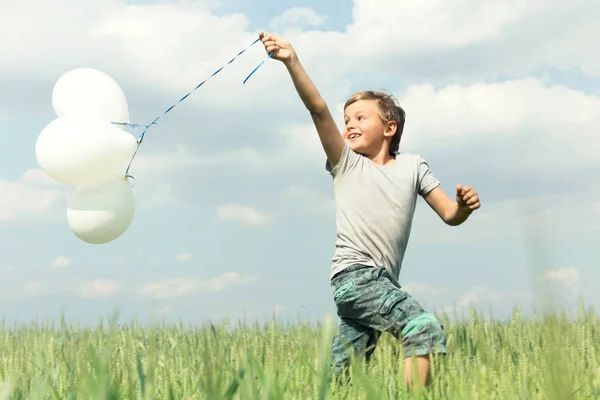 Çocuk doğanın ortasında onun balonlarla eğleniyor — Stok fotoğraf