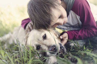 Küçük çocuk tatlı köpeğini kucaklayan