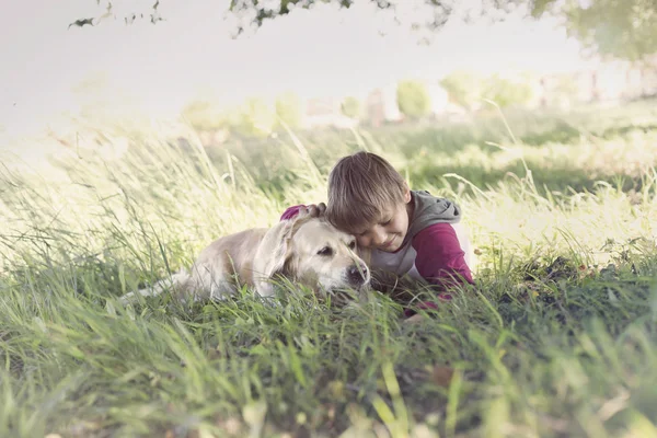 Kjærlighetens øyeblikk mellom en gutt og hunden hans – stockfoto