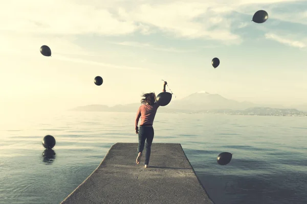 Donna in fuga da una pioggia di palloncini neri verso l'infinito con il pallone che ha scelto di portare con sé — Foto Stock