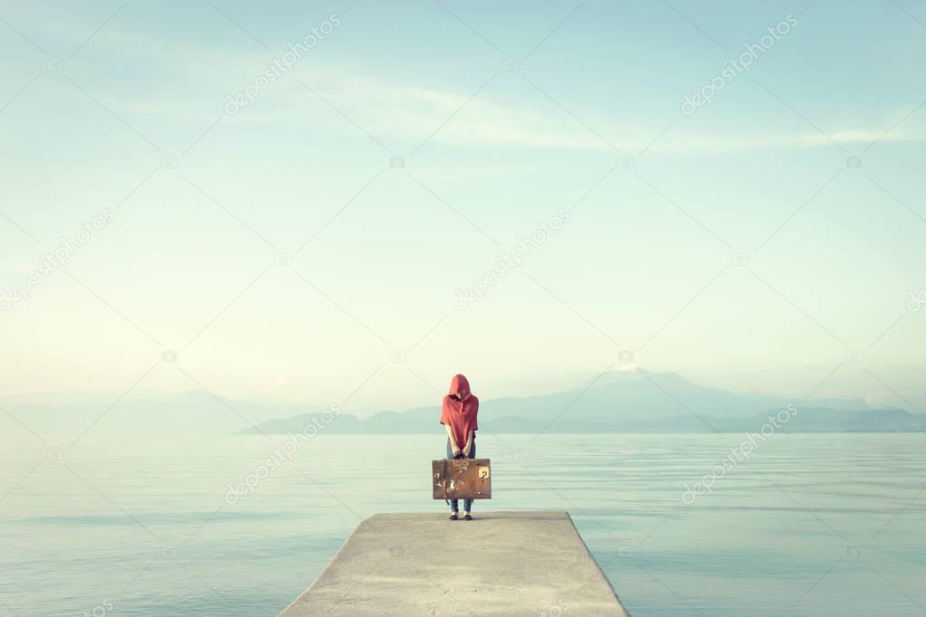  Mysterious woman in red hides her face under the hood in an enchanted lake