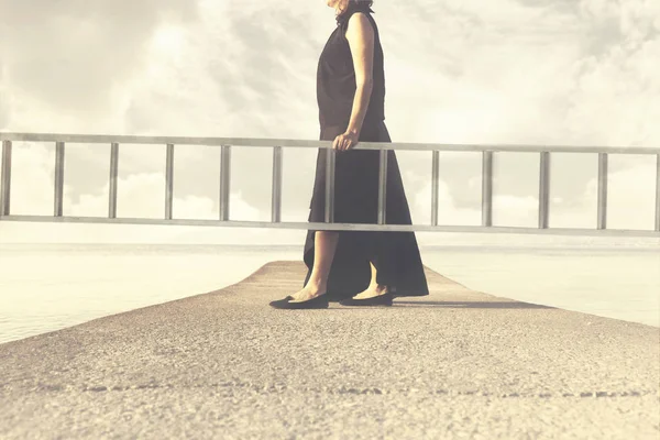 Женщина несет длинную лестницу, чтобы подняться в небо — стоковое фото