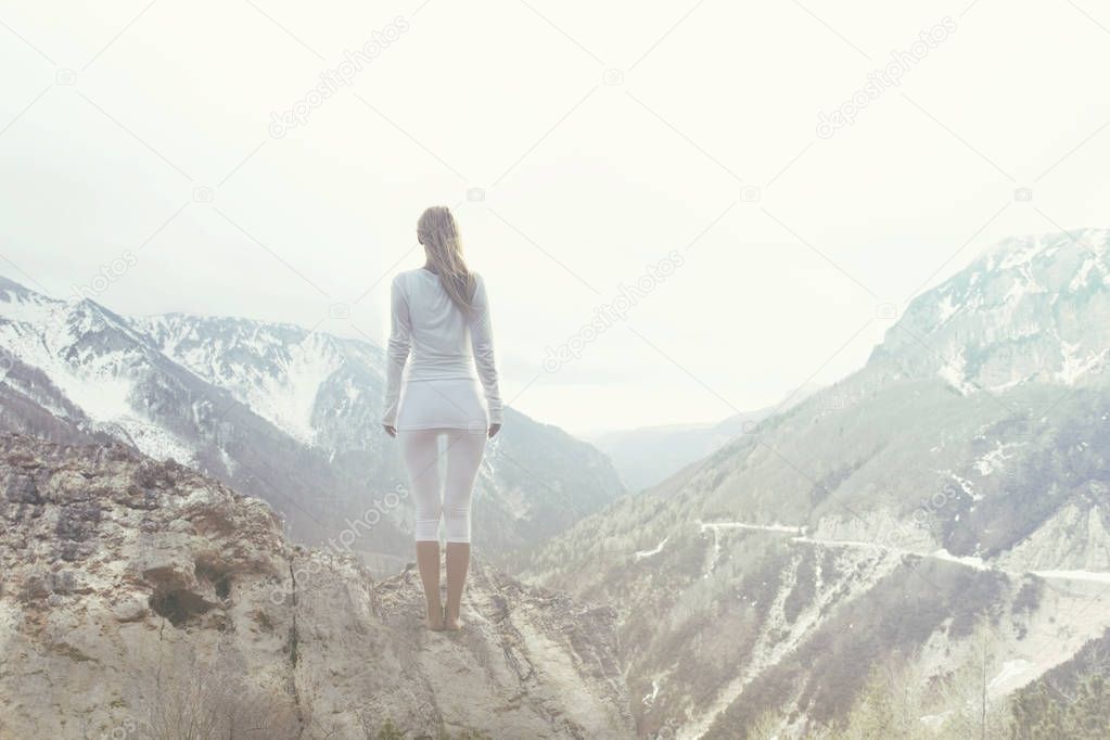 woman takes a breath on the top of a mountain
