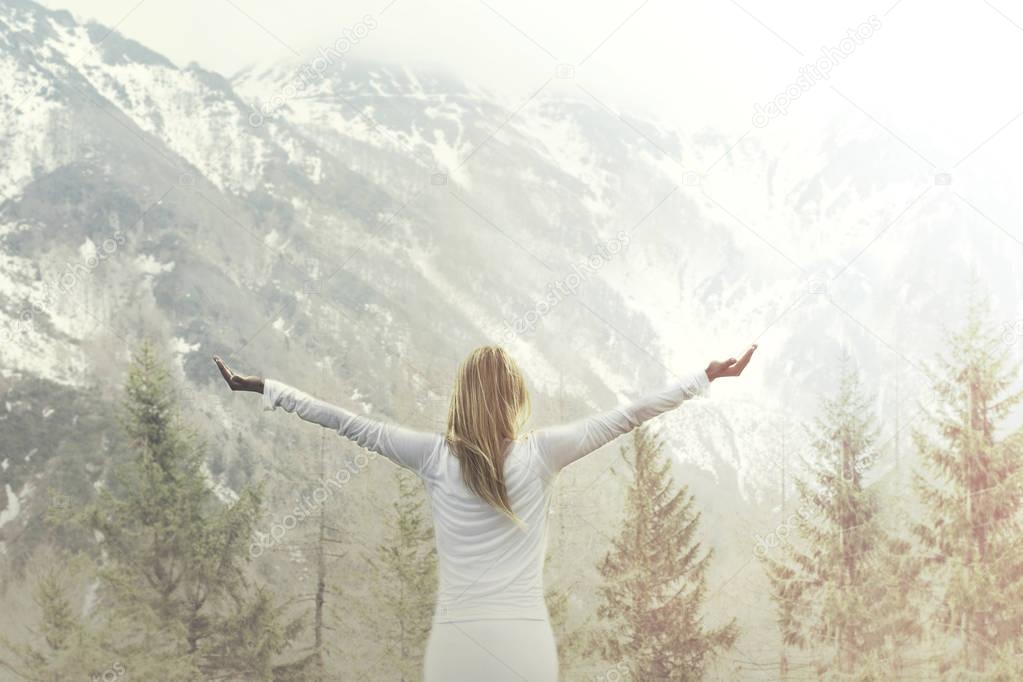 woman taking a breath in front of a majestic mountain