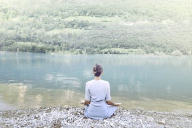muhteşem dağ gölü önünde yoga yaparken kadın