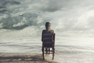 sonsuz denizin içinde bir sandalyeye oturmuş gerçeküstü kadın görünüyor