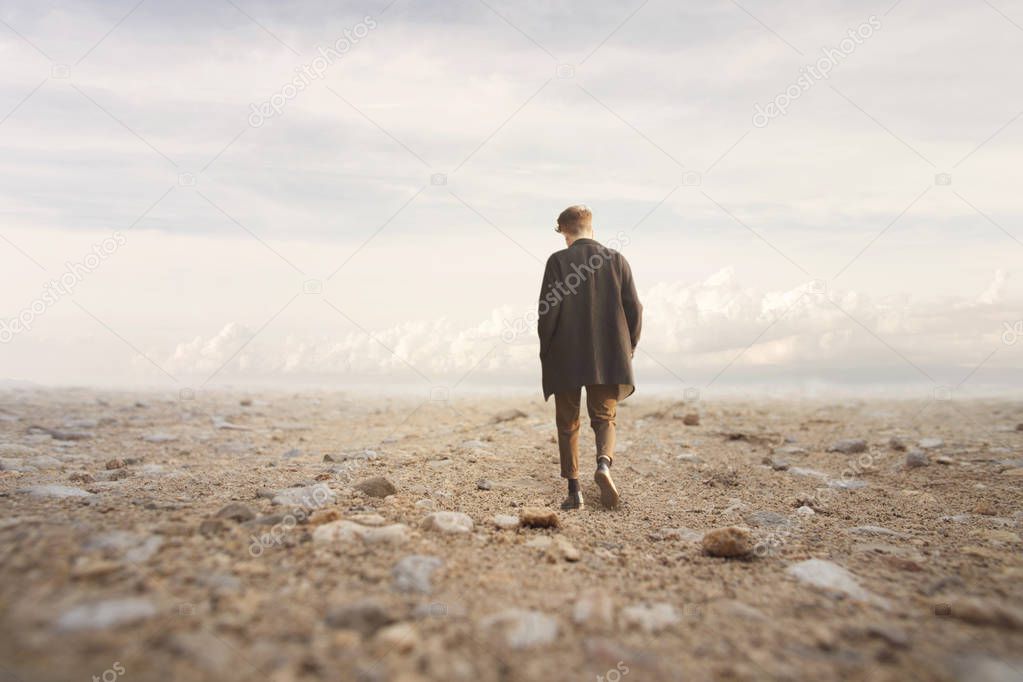 lonely man walks towards an unknown destination in a desert landscape