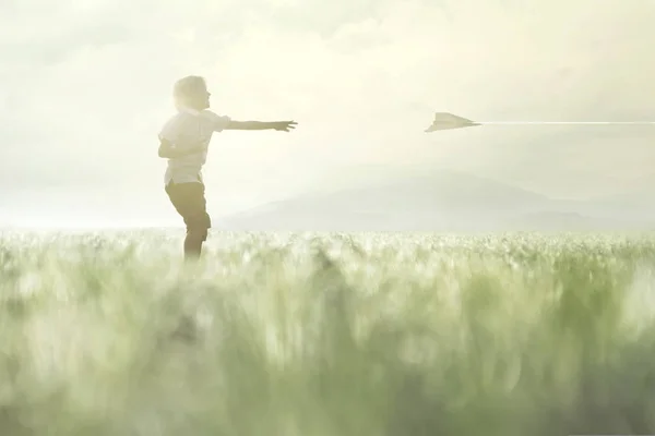 Junge Lässt Papierflugzeug Auf Einer Wiese Fliegen — Stockfoto