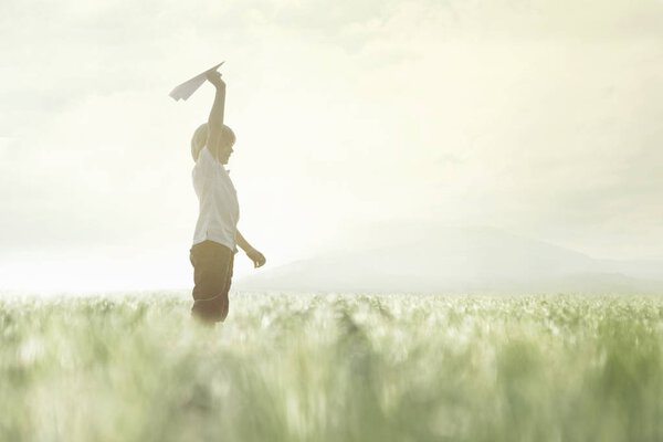 happy little boy is ready to launch his new paper airplane
