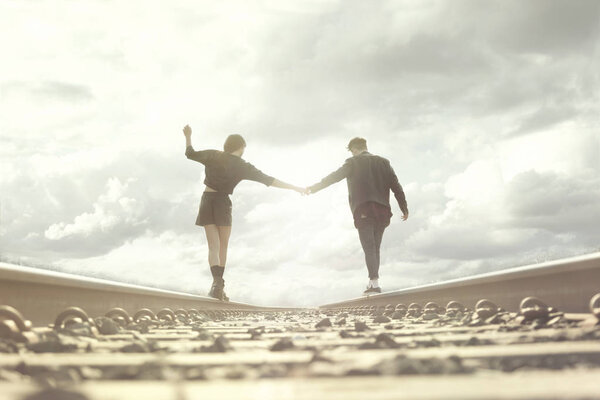 young couple walking hand in abandoned rails in a surreal place