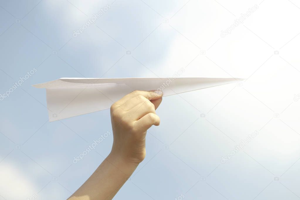 dream concept of a person flying a paper plane in the sky