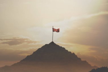 Bir dağın tepesine yerleştirilmiş bayrak, başarı konsepti