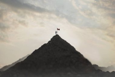 Kadın, başarının bir işareti olarak bayrağını dağın zirvesine dikti.