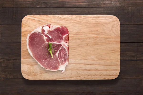 Top view raw pork chop steak on cutting board on wooden background. — Stock Photo, Image