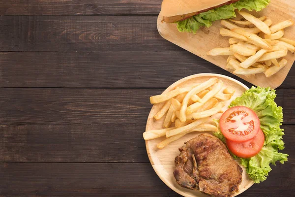 Grilled pork chop steak and hot dogs set on the wooden backgroun — Stock Photo, Image