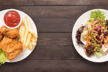 Taze salata ve kızarmış tavuk ve patates kızartması ahşap bac üzerinde
