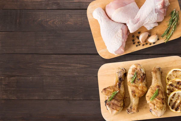 Top view raw chicken and grilled chicken on cutting board on wooden background. Copyspace for your text. — Stock Photo, Image