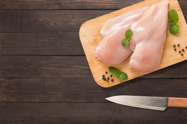 Pollo crudo vista dall'alto su tagliere e coltello su dorso in legno — Foto Stock