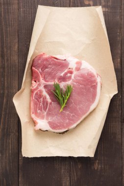 Kağıt ahşap arka plan üzerinde çiğ domuz eti biftek