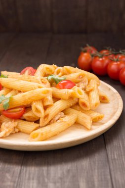Ahşap bir masa üzerinde tavuk domates soslu Penne makarna