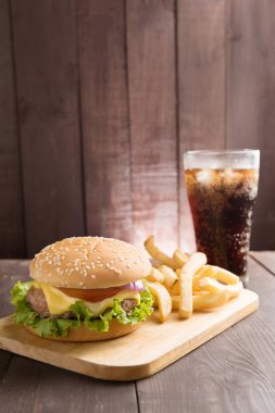 Barbekü hamburger kola ahşap arka plan üzerinde
