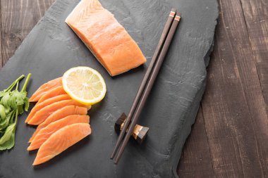 Siyah arka plan üzerine limonlu taze somon