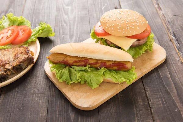 Хот-доги и гамбургеры на деревянном фоне — стоковое фото