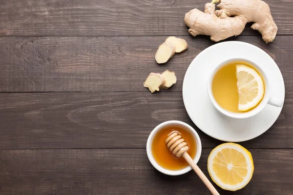 杯生姜茶和柠檬蜂蜜木制背景. — 图库照片