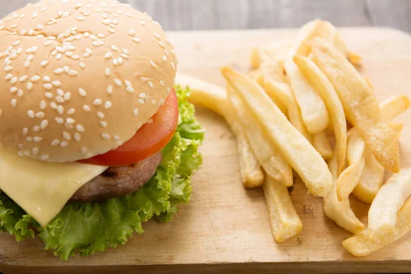 BBQ hamburgare med pommes frites på trä bakgrund — Stockfoto