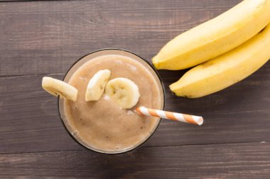 Ahşap arka plan üzerinde muz smoothie. Üstten Görünüm