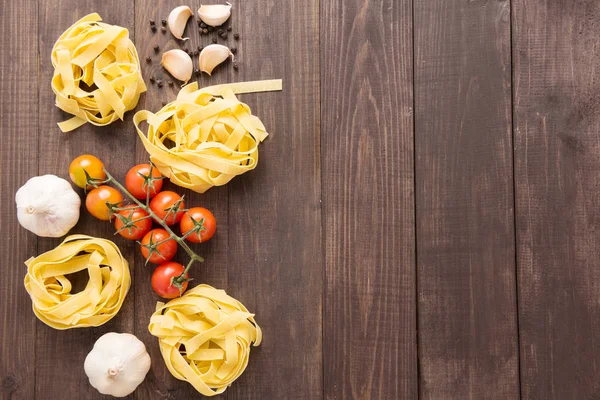 Pasta ingredientes. tomate, ajo y pimienta sobre fondo de madera — Foto de Stock